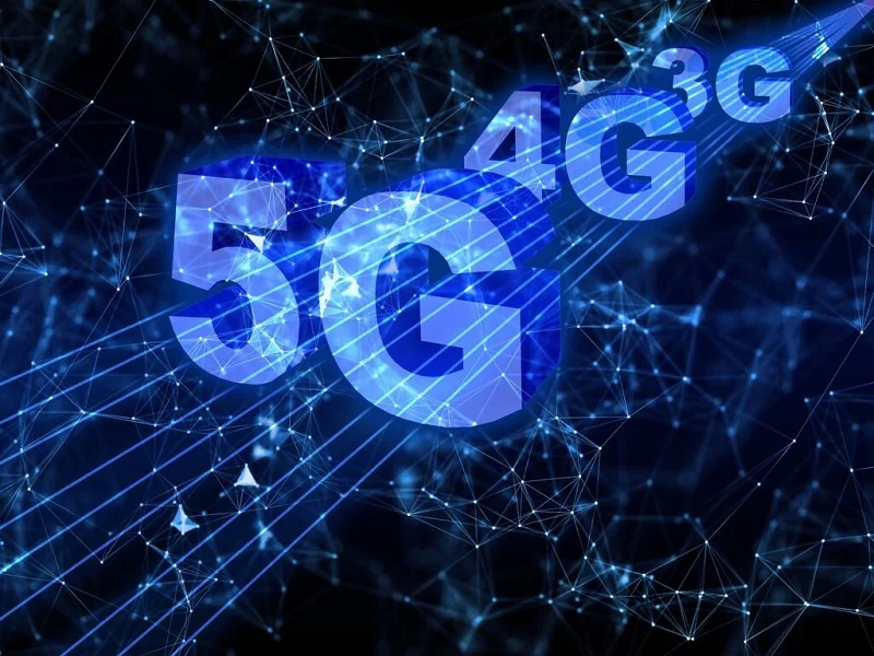 A imagem é uma renderização dos termos 5G, 4G e 3G no estilo 3D com fundo em azul escuro e letras iluminadas.