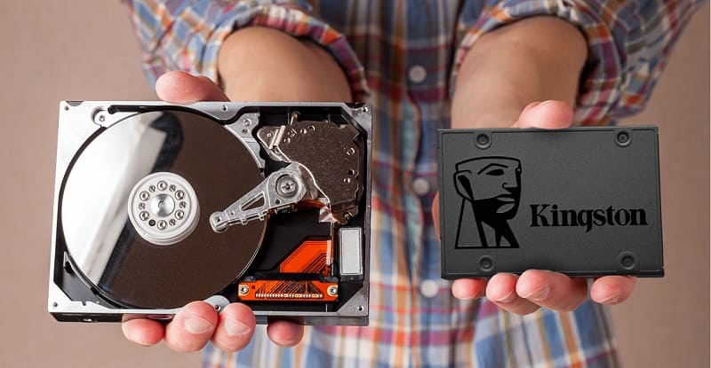 A imagem apresenta uma pessoa segurando em uma mão um Disco rígido e na outra um SSD