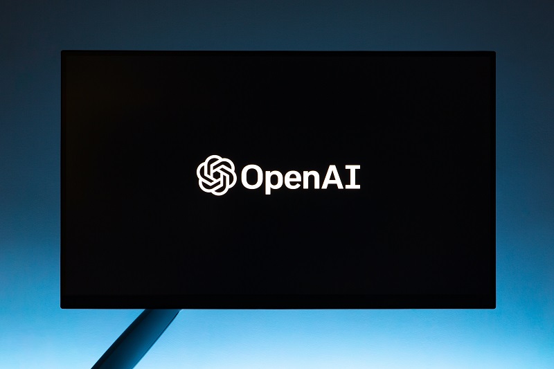 Imagem de um plano escuro em formado de monitor de computador com a logo e a frase OpenAI