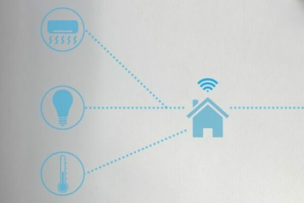 Escrivaninha branca com uma cadeira branca de costas. Em cima, um Echo Dot Amazon com Alexa e ícones azuis flutuando em um esquema de conexão de casa inteligente.