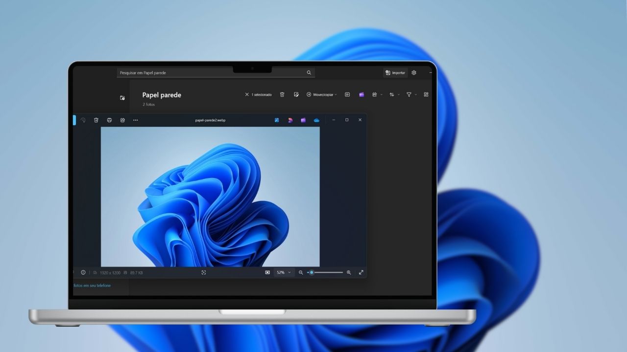 Imagem mostrando um laptop com o aplicativo de fotos do Windows 11 aberto. Na tela do laptop, é exibida uma imagem de um papel de parede azul abstrato. O aplicativo de fotos apresenta detalhes do arquivo, incluindo o nome 'papel-parede2.webp', as dimensões da imagem (1920 x 1200) e o tamanho do arquivo (897 KB). O fundo da imagem também é uma versão ampliada do mesmo papel de parede azul abstrato. Imagem: reprodução.