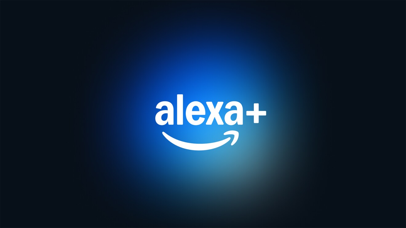 Imagem com fundo azul escuro e um gradiente de azul mais claro no centro, onde está escrito 'alexa+' em letras brancas. Abaixo do texto, há uma seta curva que se assemelha a um sorriso, também em branco. Créditos: Amazon divulgação.