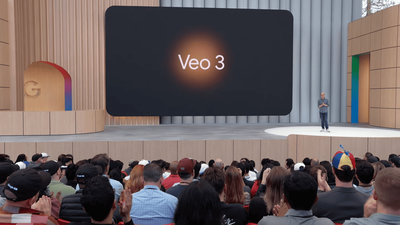 Imagem de uma apresentação da Google, onde um palestrante está em um palco com um grande telão atrás dele exibindo o texto