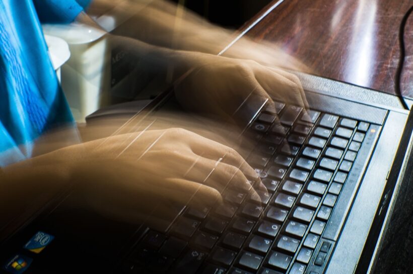 Mãos digitando rapidamente em um notebook, com efeito de movimento que representa atividades de informática, programação, cibersegurança ou ataques virtuais, ilustrando temas relacionados a golpes digitais, hackers e segurança da informação. Créditos: imagem de Nothing Ahead / Pexels.